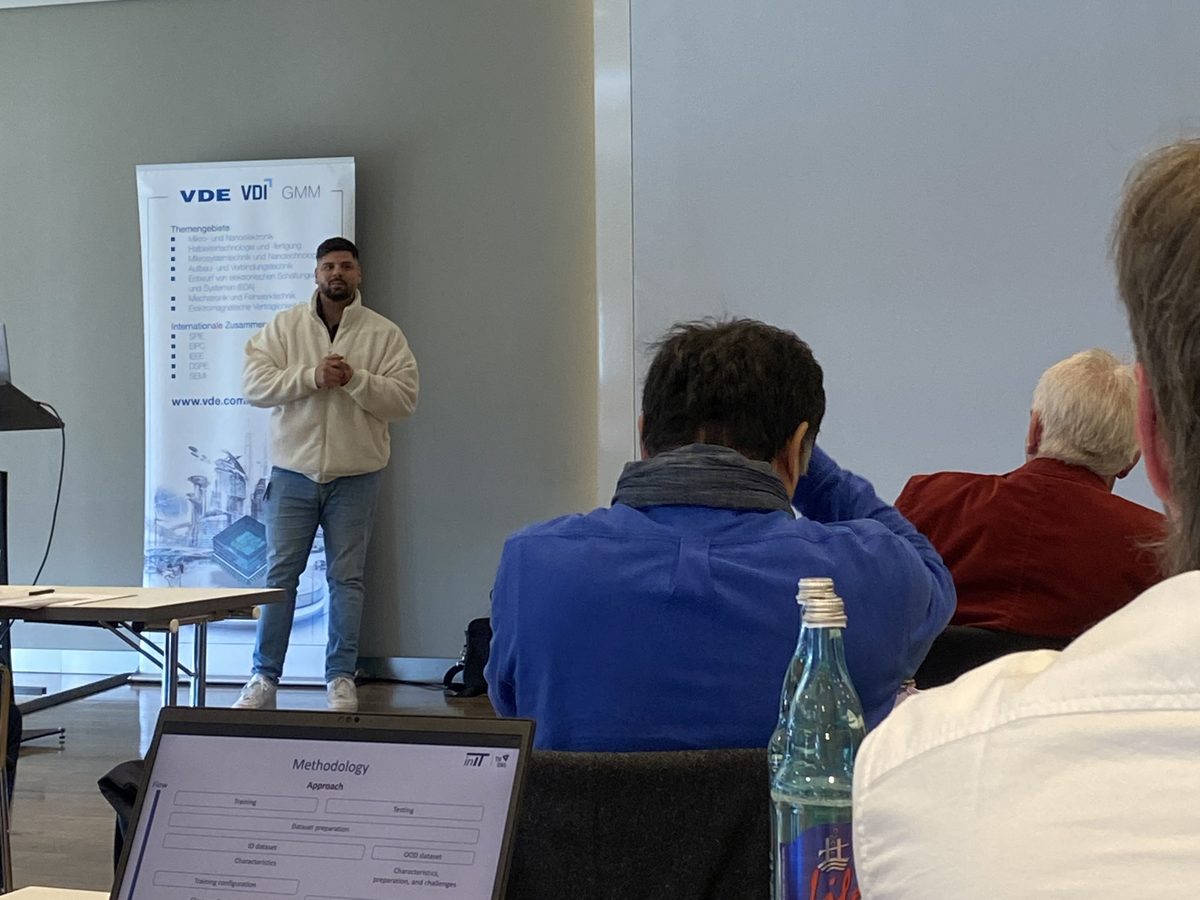 Aiman El Asad spricht vor einem VDE/VDI-GMM-Banner, AmEC 2026